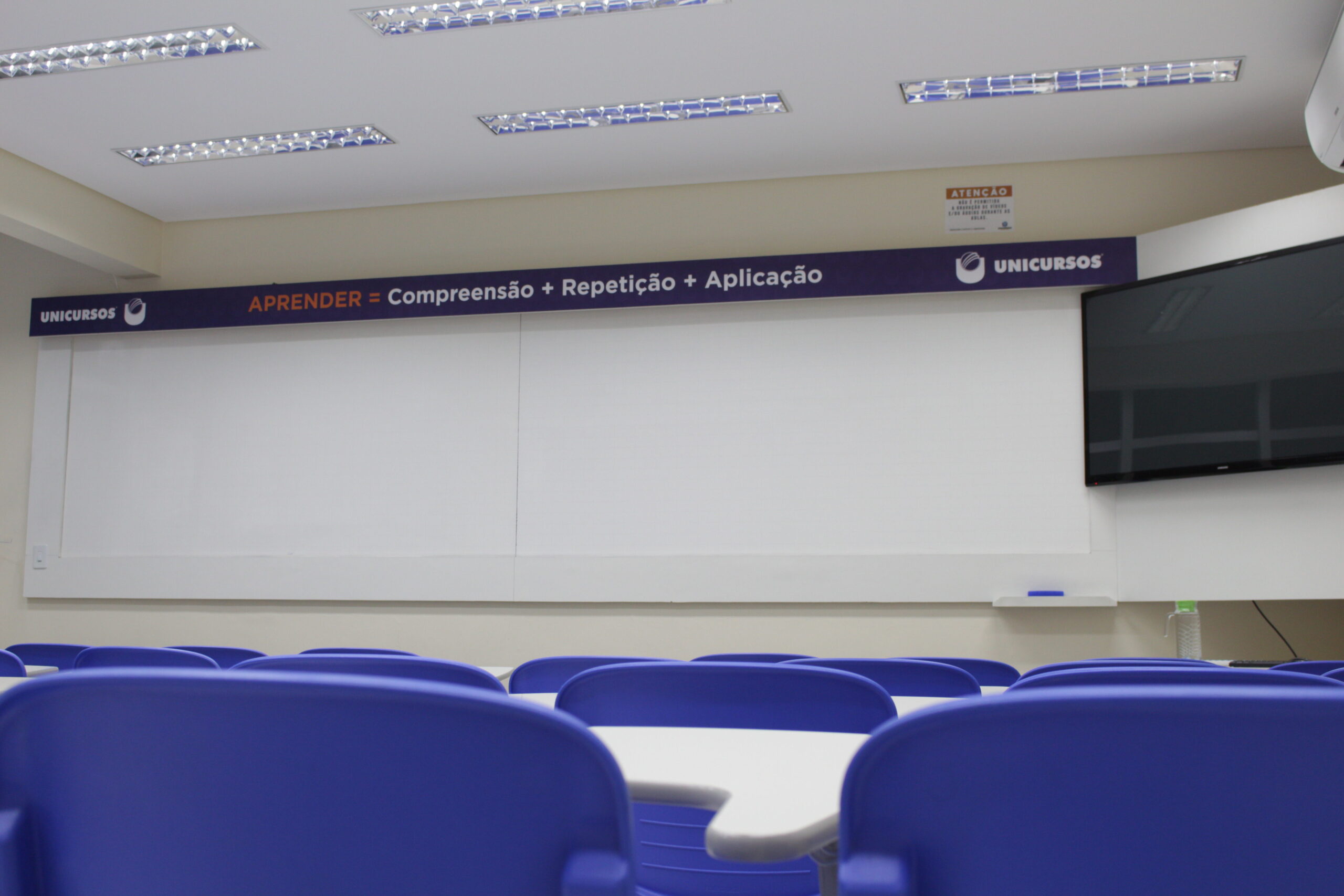 Sala de aula do Unicursos, com carteiras azuis e quadro de ensino